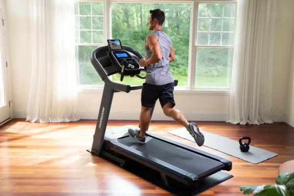 horizon | 7.4 at treadmill 3.5 hp Man running on Horizon treadmill in bright home gym