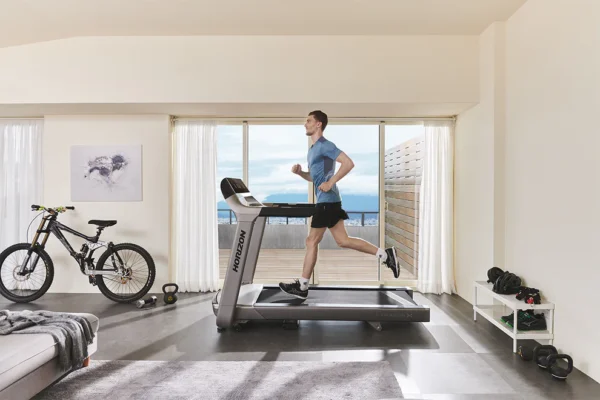 horizon | paragon x 3.25 hp Man running on Horizon treadmill in modern home gym
