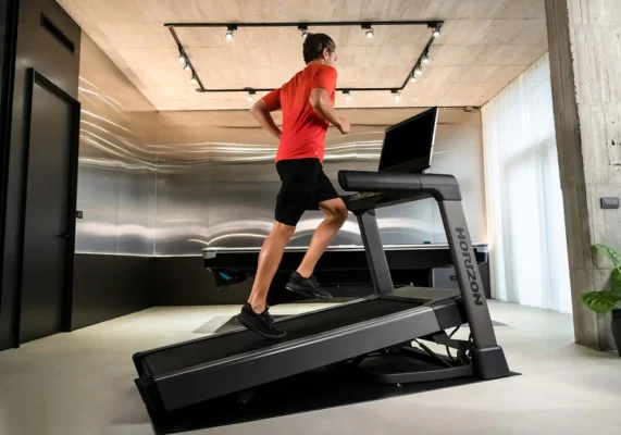 Man in red shirt running on Horizon treadmill indoors