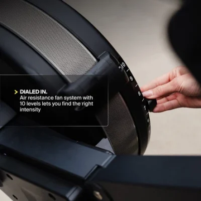centr x hyrox | perform series rower Hand adjusting resistance dial on air resistance rowing machine