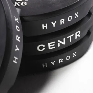 Stacked black HYROX and CENTR weight plates close-up