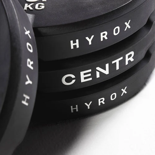 Stacked black HYROX and CENTR weight plates close-up